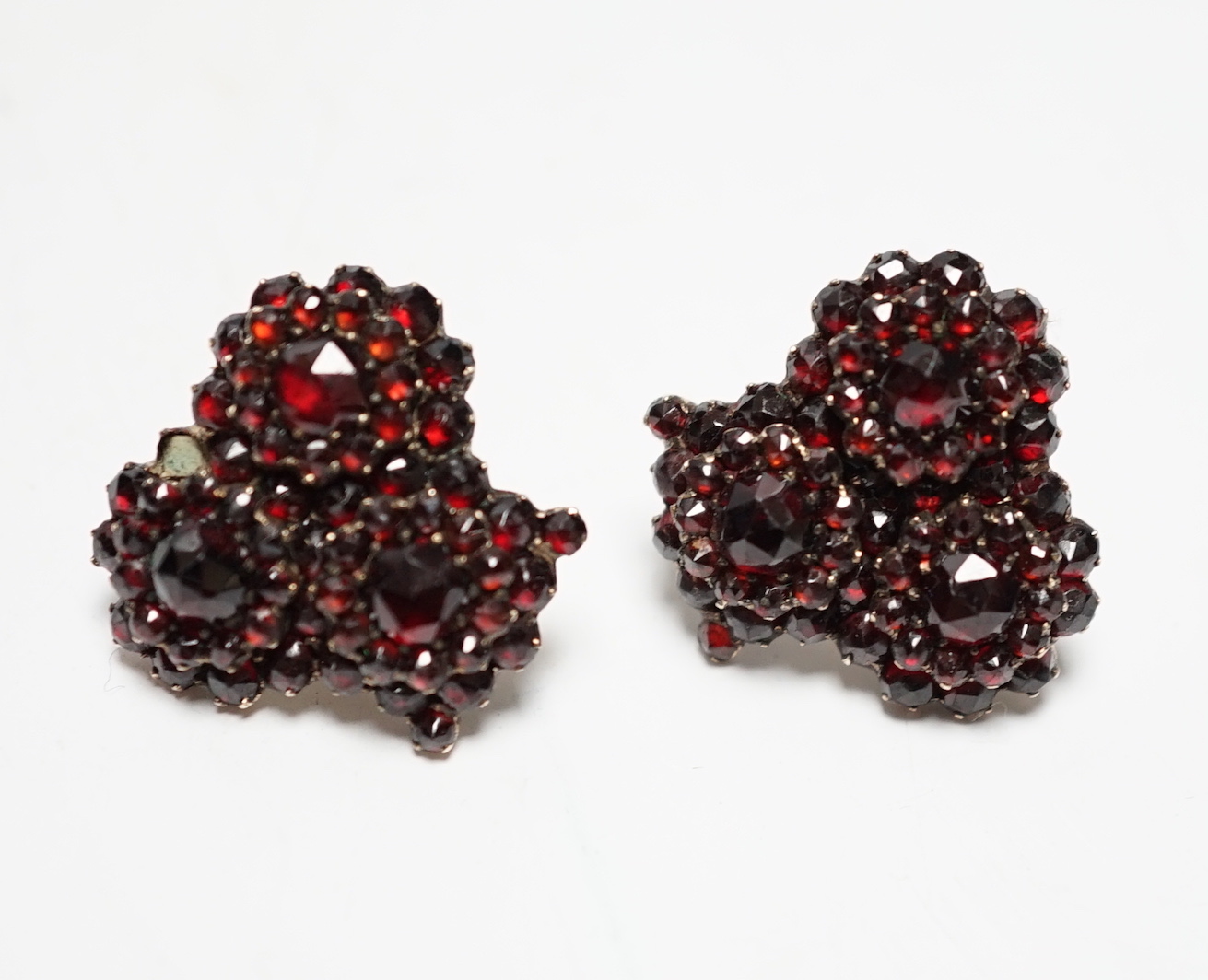 A pair of Edwardian gilt white metal and garnet coloured paste set triple cluster earrings, diameter 18mm.